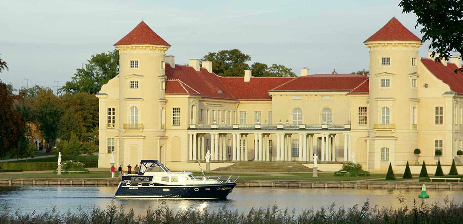 Das Schloss Rheinsberg erstrahlt nach umfangreichen Sanierungsarbeiten wieder im herrschaftlichen Glanz vergangener Zeiten und kann beim Hausboot mieten in der Mecklenburgischen Kleinseenplatte vom Wasser aus besichtigt werden. © Magazin Seenland